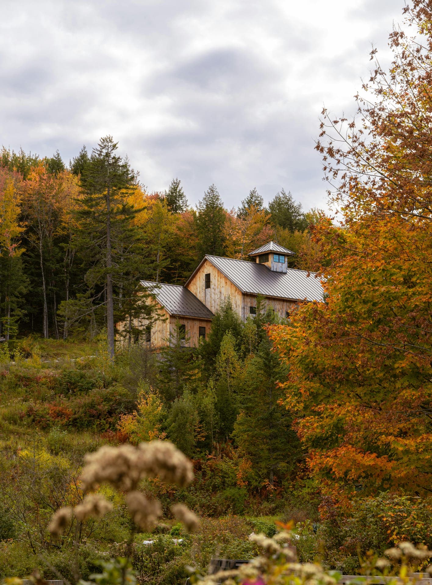 Wood-sided Vermont home set against autumn foliage
