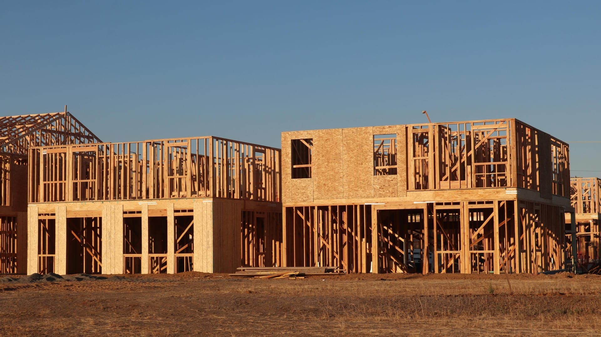 Wood-framed home under construction at sunset, ready for engineered siding